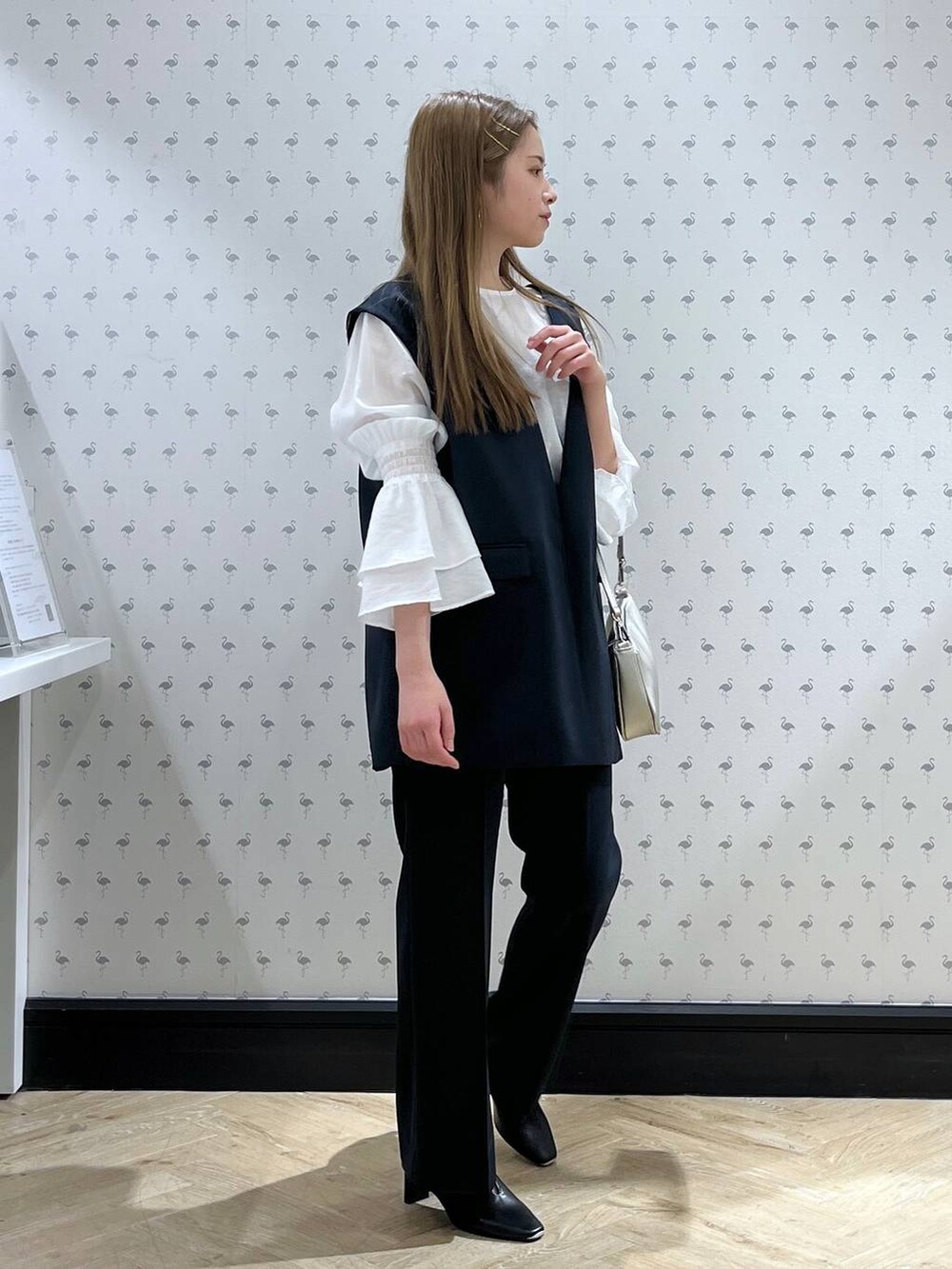 ブルー系のパンツドレス、シルバー系のショルダーバッグ、ブラック系のパンプスを着用したレディースの冬コーディネートの4枚目の写真