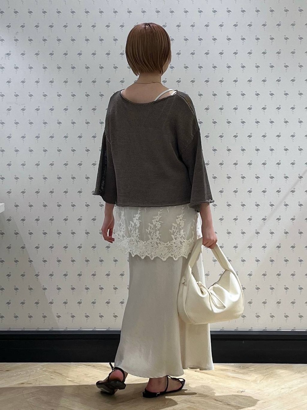 ホワイト系のTシャツ/カットソー、ホワイト系のハンドバッグ、ブラウン系のサンダルを着用したレディースの秋コーディネートの3枚目の写真