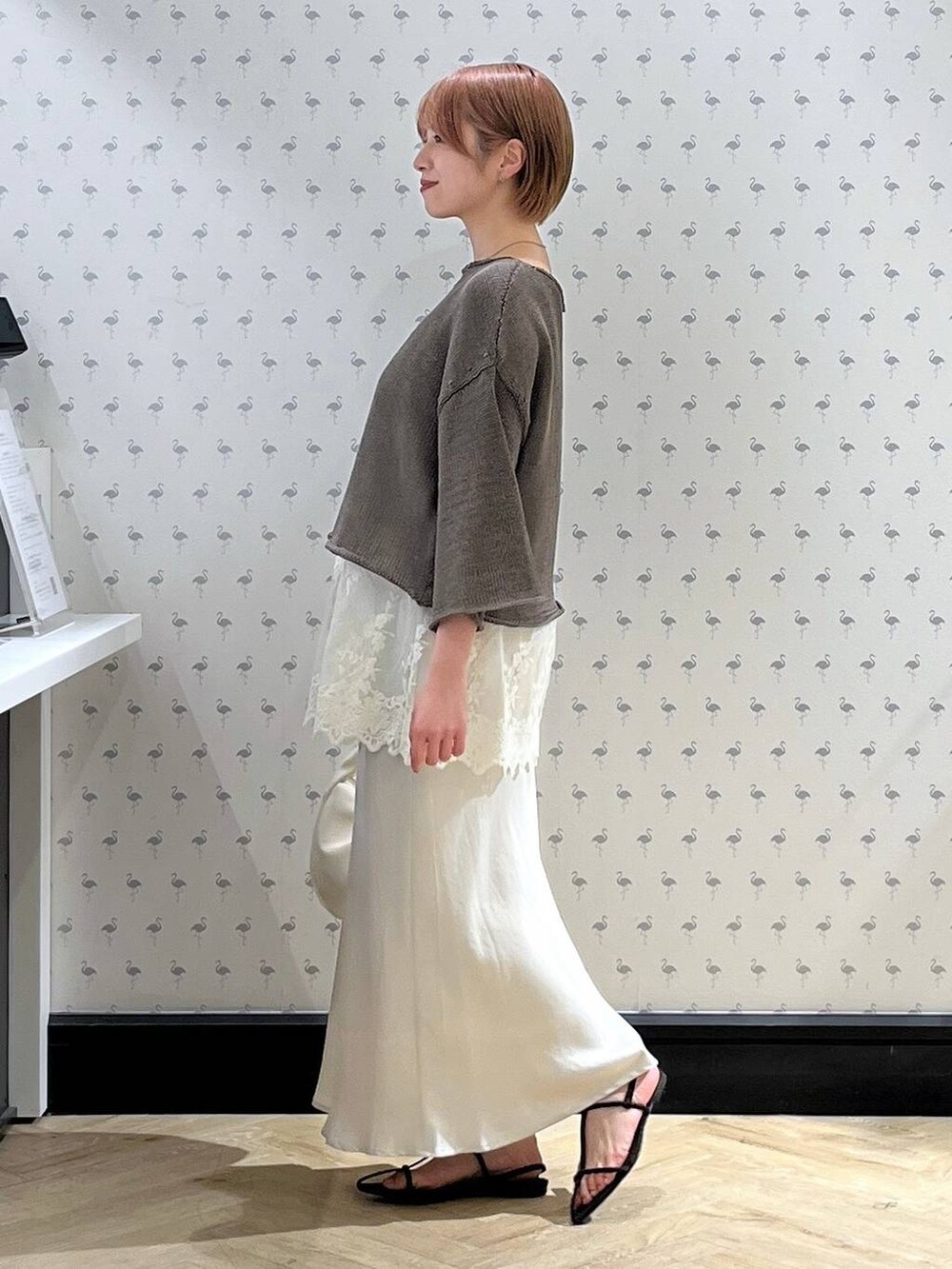 ホワイト系のTシャツ/カットソー、ホワイト系のハンドバッグ、ブラウン系のサンダルを着用したレディースの秋コーディネートの2枚目の写真