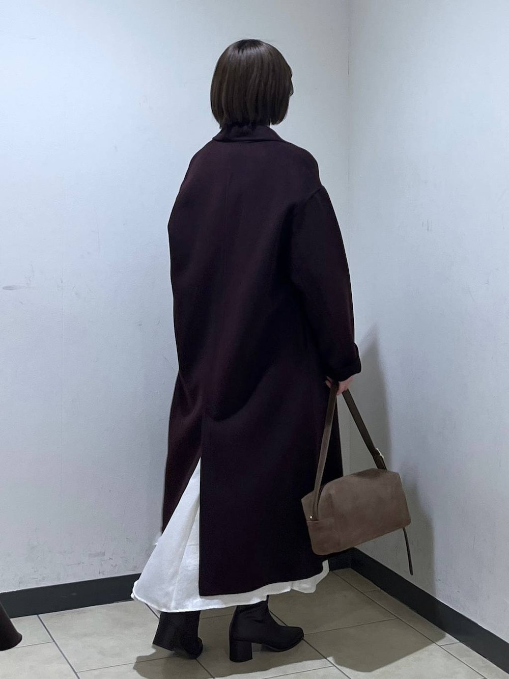 ブラウン系のブーツ、ベージュ系のカーディガン/ボレロ、レッド系のチェスターコートを着用したレディースの秋コーディネートの2枚目の写真