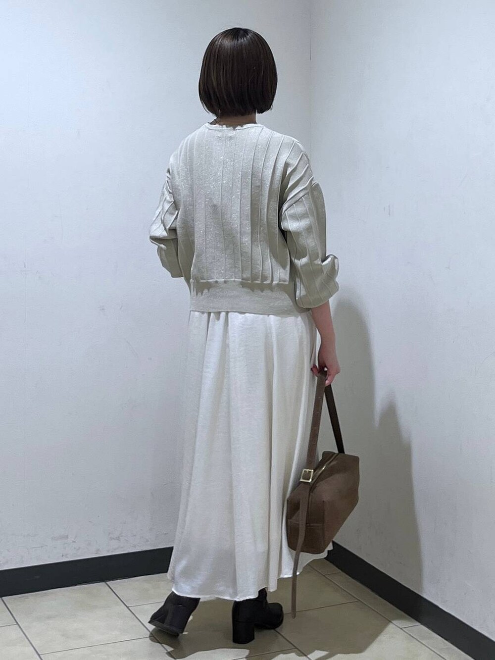 ブラウン系のブーツ、ベージュ系のカーディガン/ボレロ、ホワイト系のスカートを着用したレディースの秋コーディネートの3枚目の写真