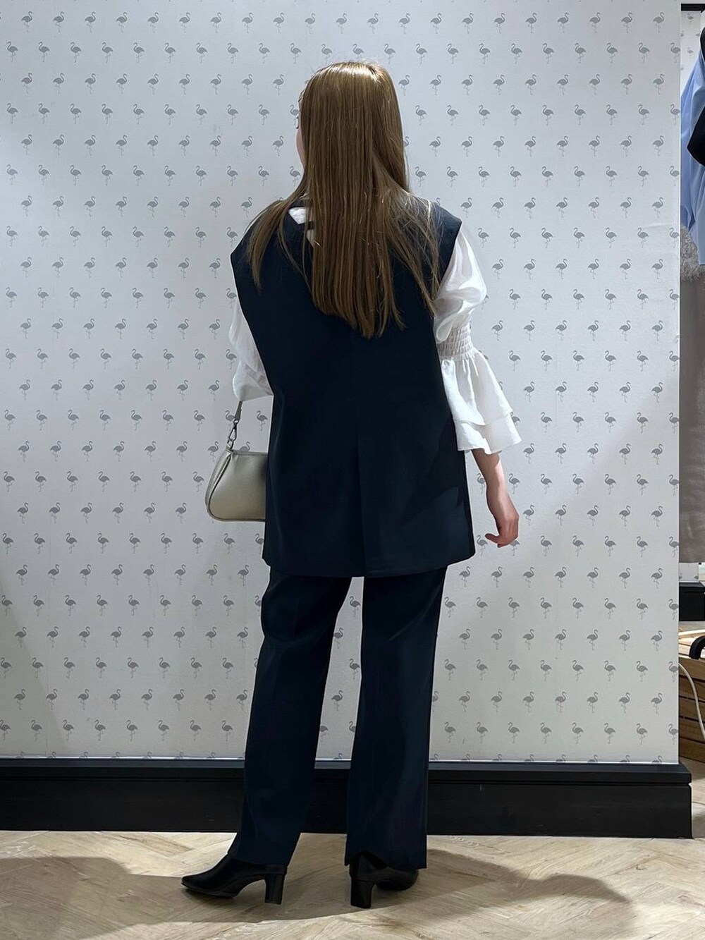 ブルー系のパンツドレス、シルバー系のショルダーバッグ、ブラック系のパンプスを着用したレディースの冬コーディネートの3枚目の写真