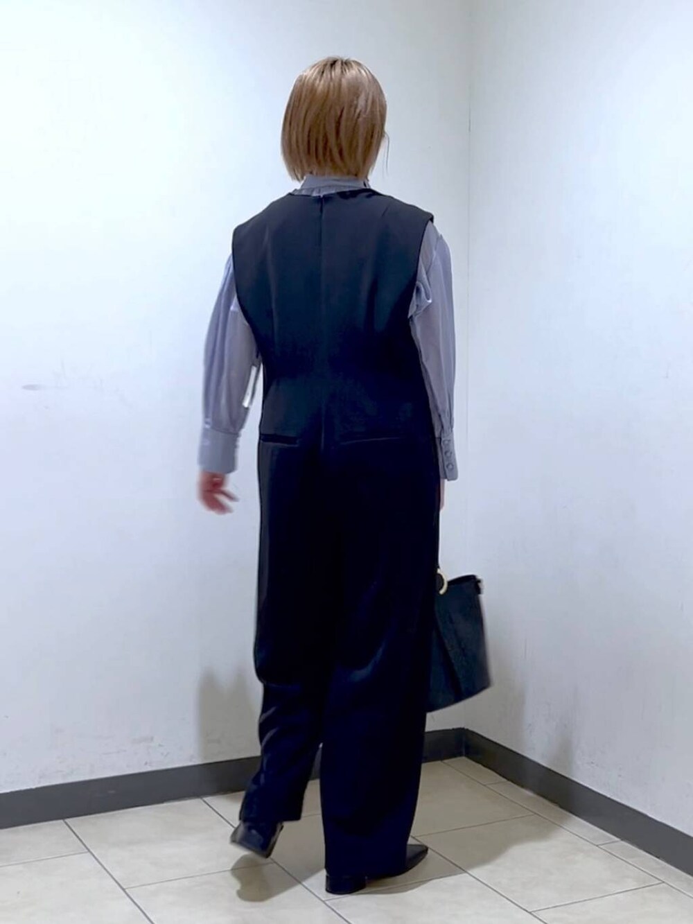 ブラック系のショルダーバッグ、ブラック系のパンプス、ブルー系のシャツ/ブラウスを着用したレディースの冬コーディネートの2枚目の写真