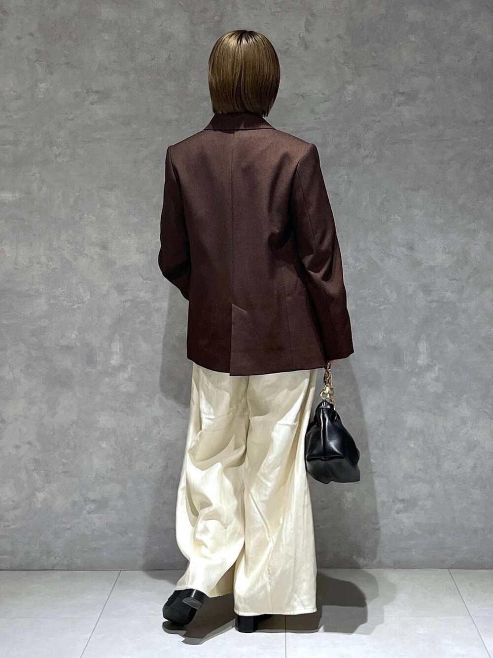 ホワイト系のその他パンツ、ブラウン系のテーラードジャケット、ブラック系のショルダーバッグを着用したレディースの秋コーディネートの3枚目の写真