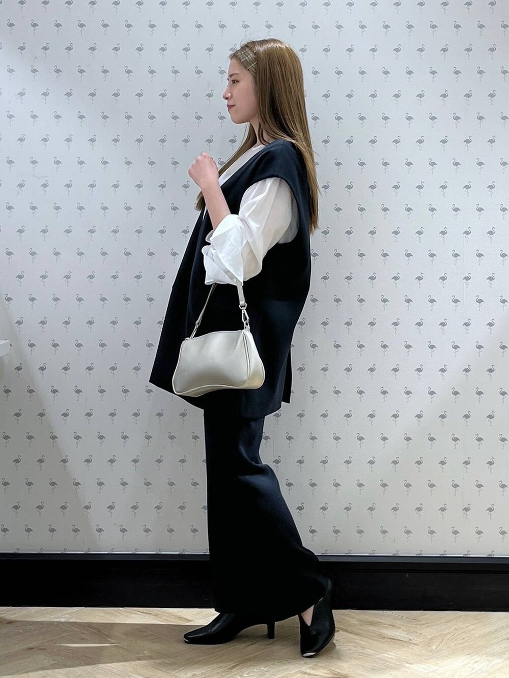 ブルー系のパンツドレス、シルバー系のショルダーバッグ、ブラック系のパンプスを着用したレディースの冬コーディネートの2枚目の写真