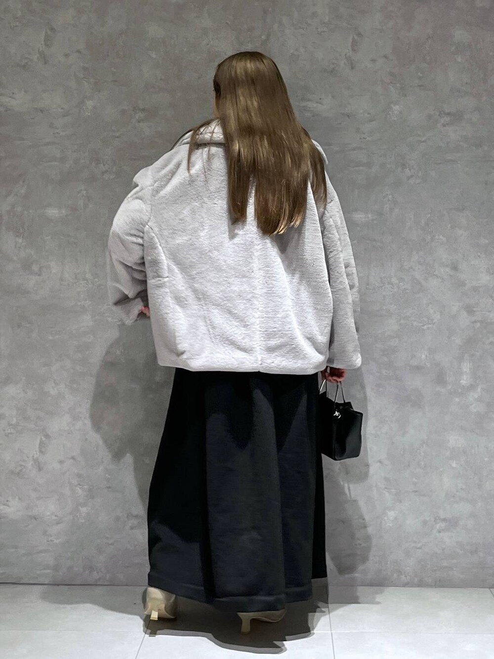 グレー系のその他アウター、ホワイト系のブーツ、ブラック系のワンピースを着用したレディースの冬コーディネートの3枚目の写真