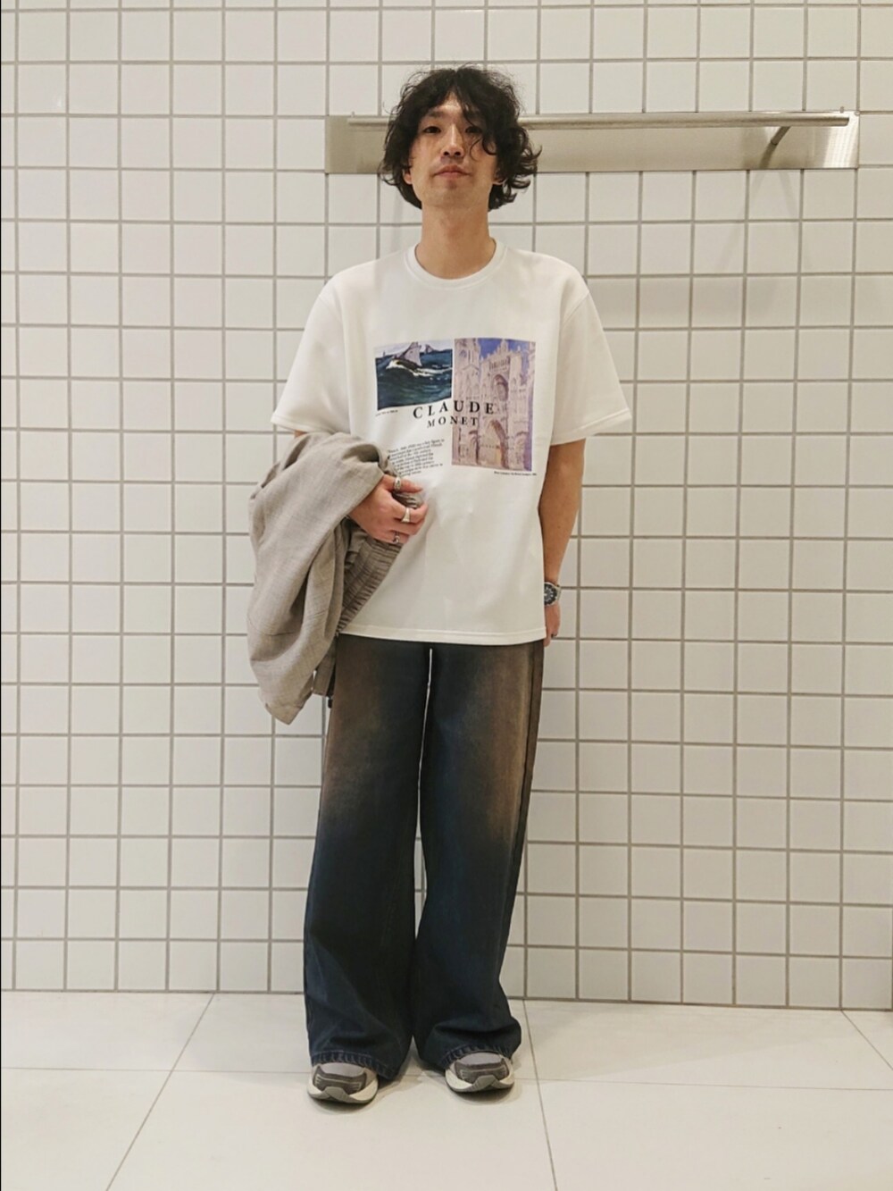 ベージュ系のブルゾン、ホワイト系のTシャツ/カットソー、ブルー系のデニムパンツを着用したメンズの秋コーディネートの3枚目の写真