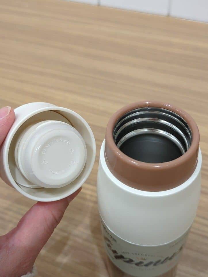 ブラック系のトートバッグ、ピンク系の水筒、ホワイト系の水筒を着用したレディースの冬コーディネートの4枚目の写真