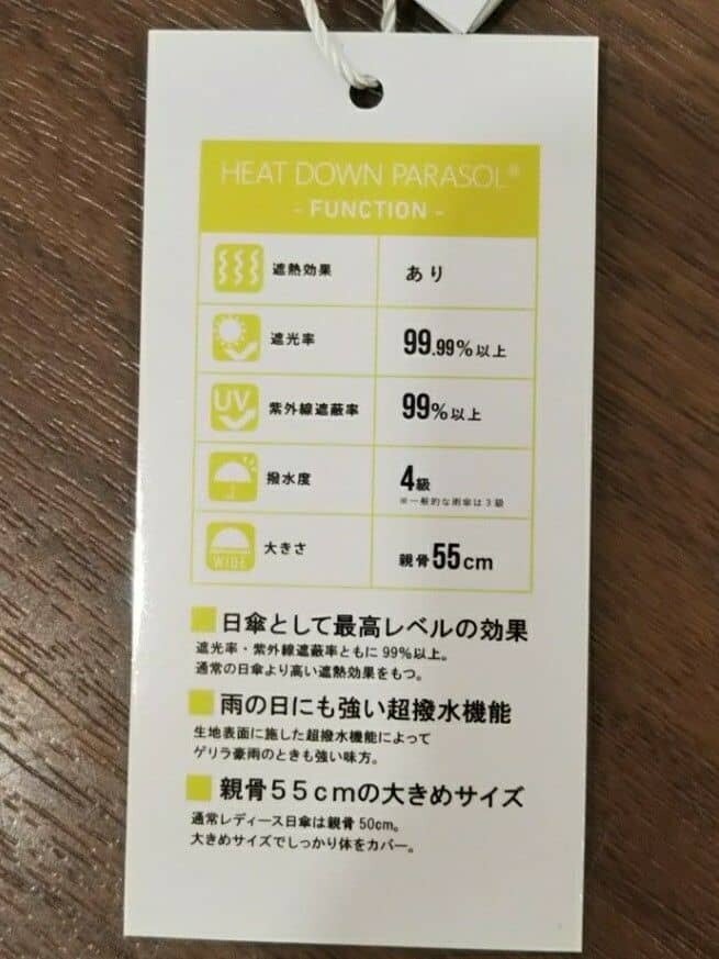 ベージュ系の折りたたみ傘、ブラック系の折りたたみ傘を着用したレディースの春コーディネートの4枚目の写真