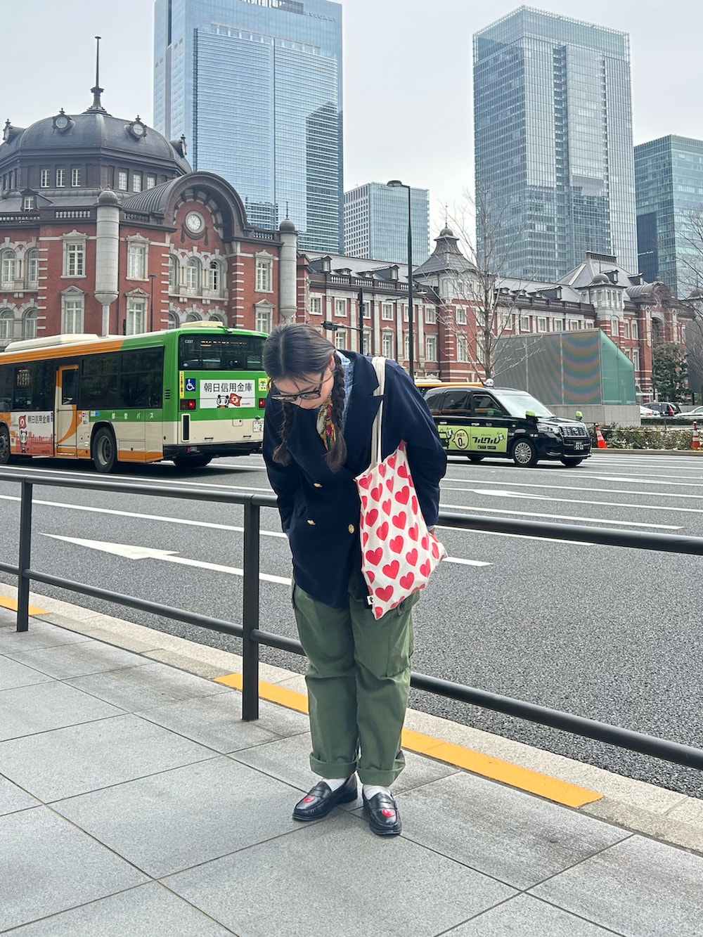 レッド系のトートバッグ、ブラック系のローファーを着用したレディースの春コーディネートの2枚目の写真