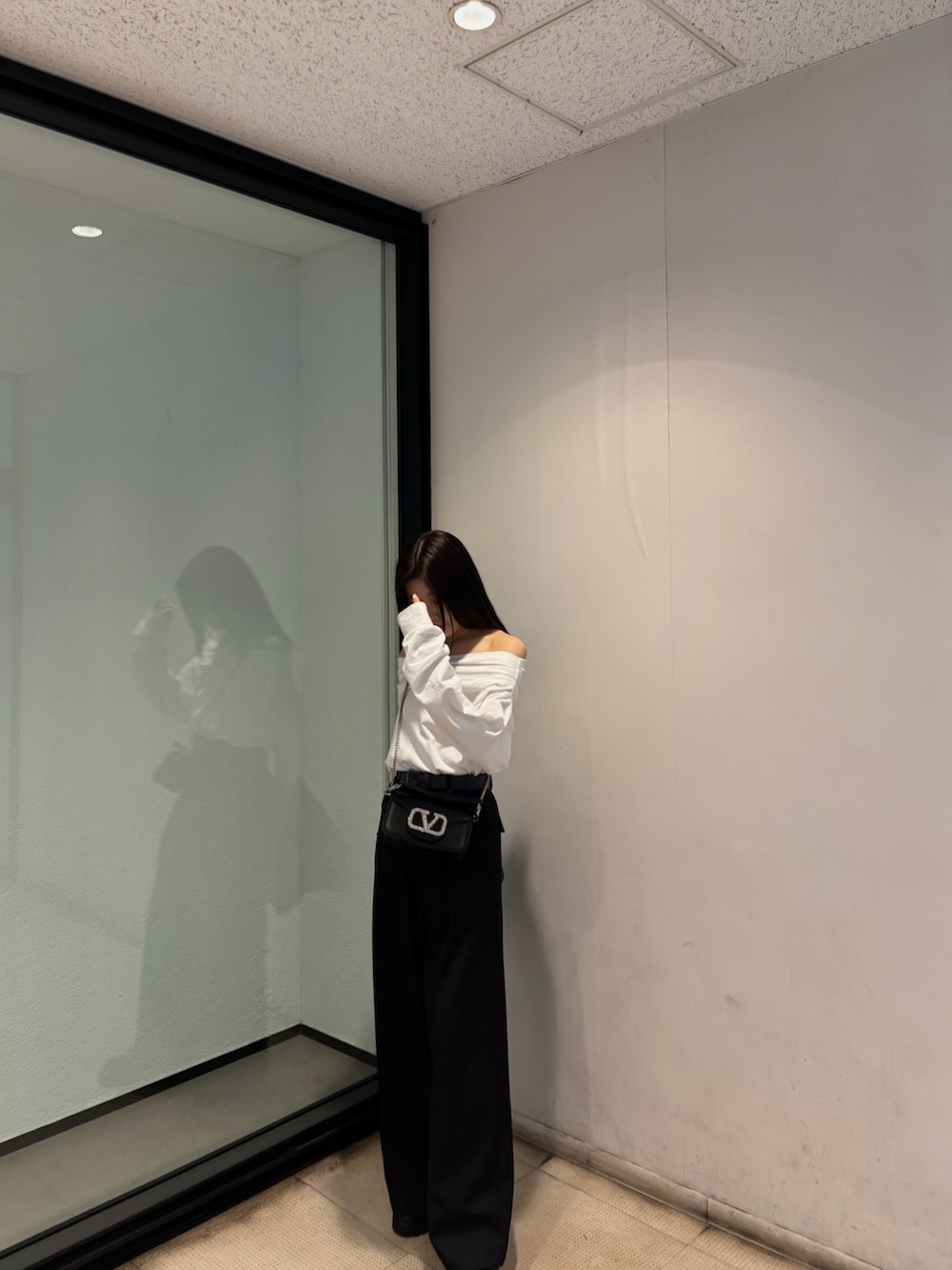 ブラック系のスラックス、ホワイト系のTシャツ/カットソー、ブラック系のテーラードジャケットを着用したレディースの春コーディネートの2枚目の写真