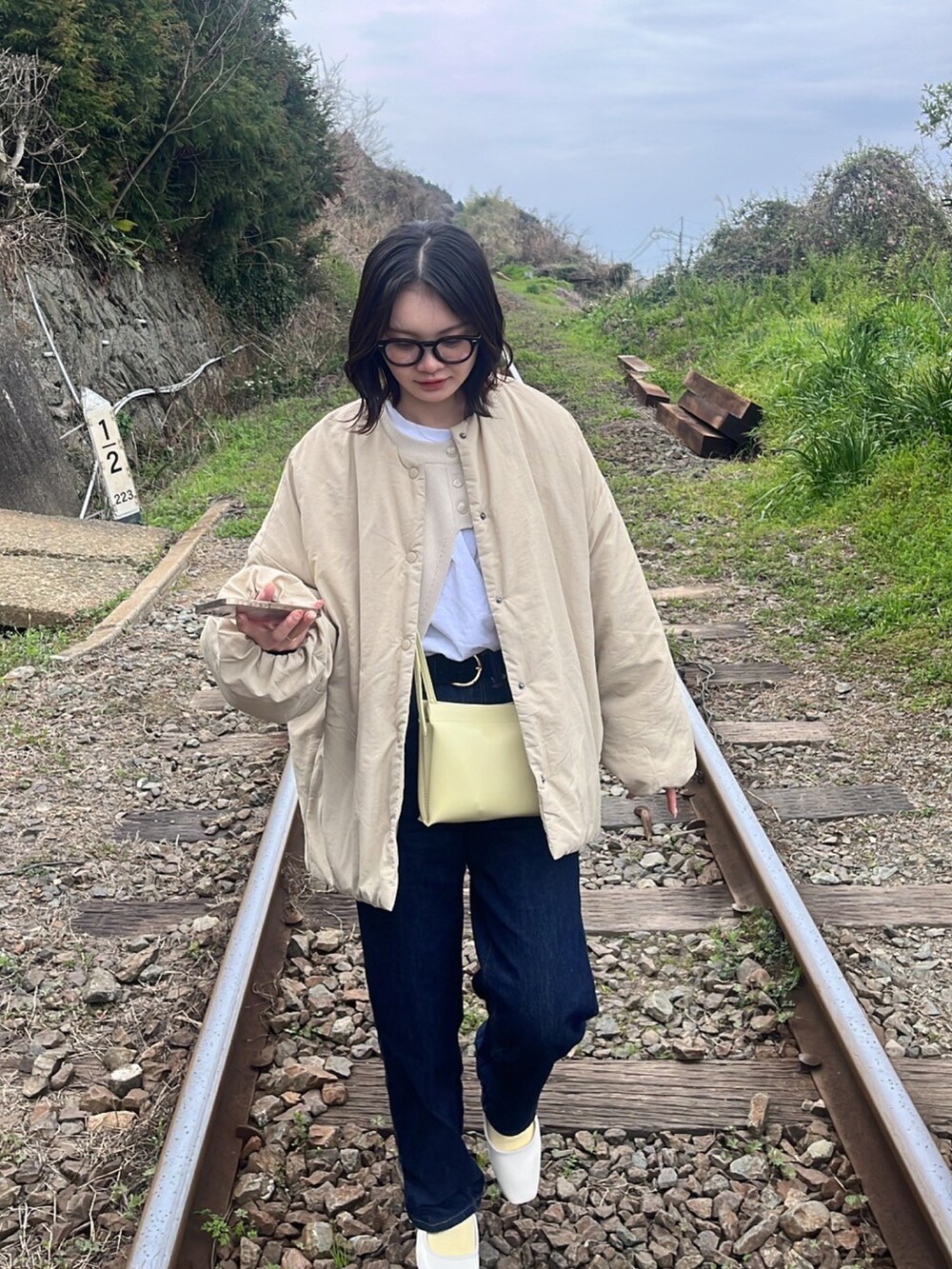 ブルー系のデニムパンツ、ホワイト系のトップスを着用したレディースの春コーディネートの2枚目の写真