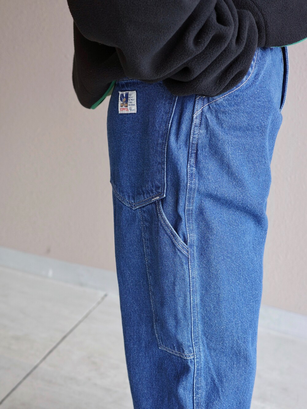 ブラック系のスウェット、ブルー系のデニムパンツ、グリーン系のニット/セーターを着用したメンズの秋コーディネートの5枚目の写真