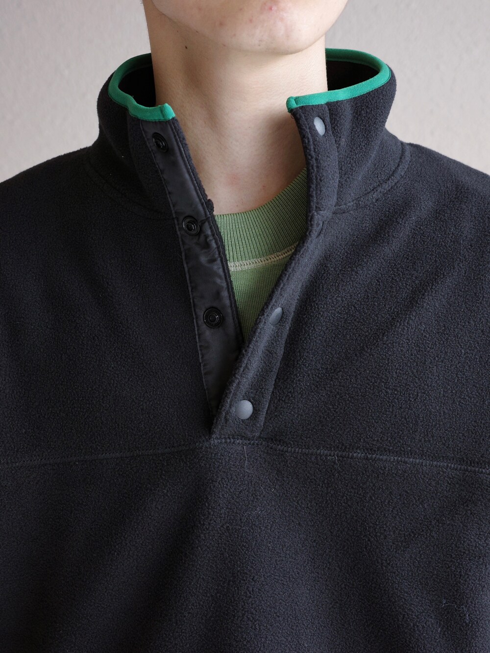 ブラック系のスウェット、ブルー系のデニムパンツ、グリーン系のニット/セーターを着用したメンズの秋コーディネートの2枚目の写真