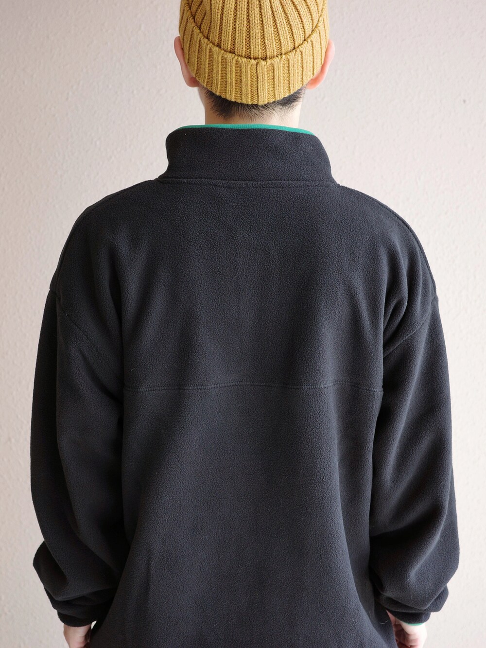 ブラック系のスウェット、ブルー系のデニムパンツ、グリーン系のニット/セーターを着用したメンズの秋コーディネートの3枚目の写真