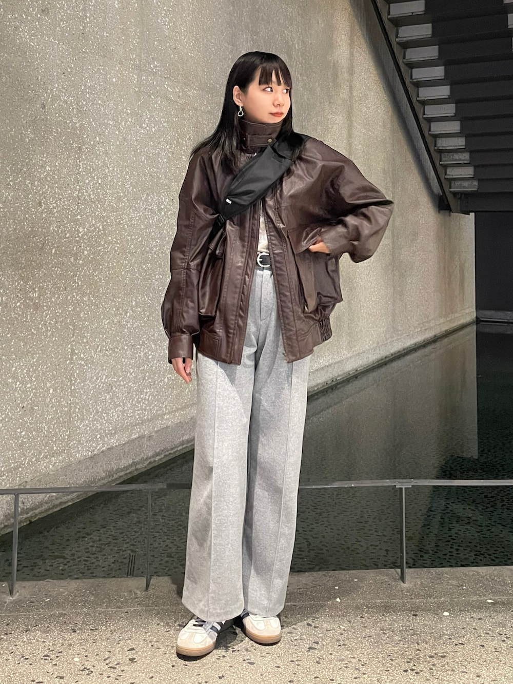 ブラウン系のブルゾン、ベージュ系のTシャツ/カットソー、ブラック系のショルダーバッグを着用したレディースの秋コーディネートの2枚目の写真