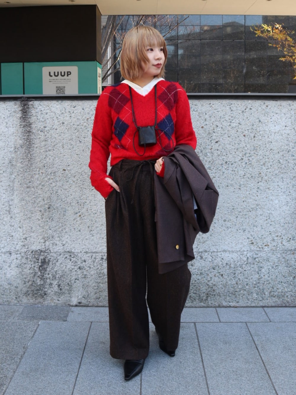 ブラウン系のテーラードジャケット、レッド系のニット/セーター、ブラウン系のその他パンツを着用したレディースの冬コーディネートの2枚目の写真