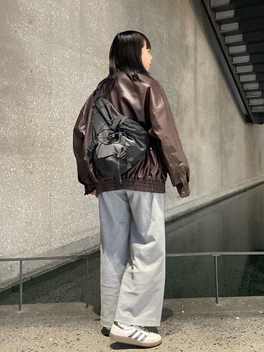 ブラウン系のブルゾン、ベージュ系のTシャツ/カットソー、ブラック系のショルダーバッグを着用したレディースの秋コーディネートの3枚目の写真