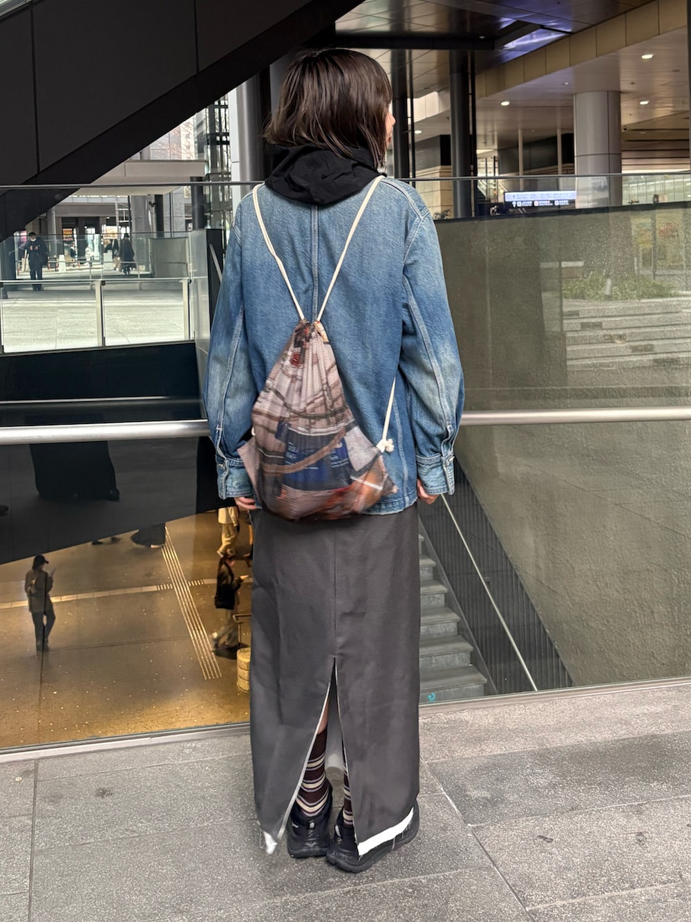 ブラック系のシャツ/ブラウス、グレー系のスカート、ブルー系のデニムジャケットを着用したレディースの冬コーディネートの2枚目の写真