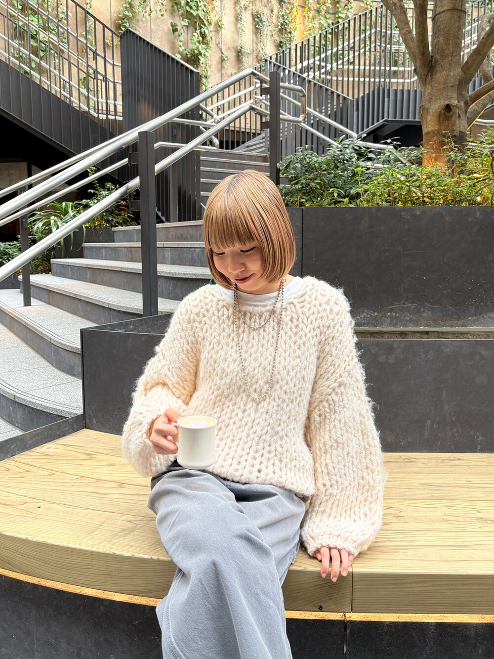 ホワイト系のニット/セーター、グレー系のその他パンツ、ブラック系のパンプスを着用したレディースの冬コーディネートの2枚目の写真