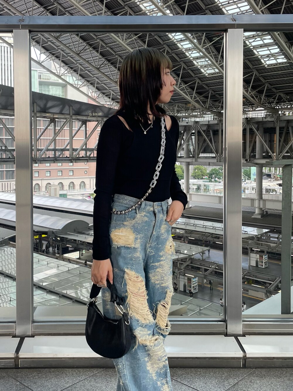 ブラック系のTシャツ/カットソー、ブルー系のデニムパンツ、ブラック系のブーツを着用したレディースの秋コーディネートの2枚目の写真