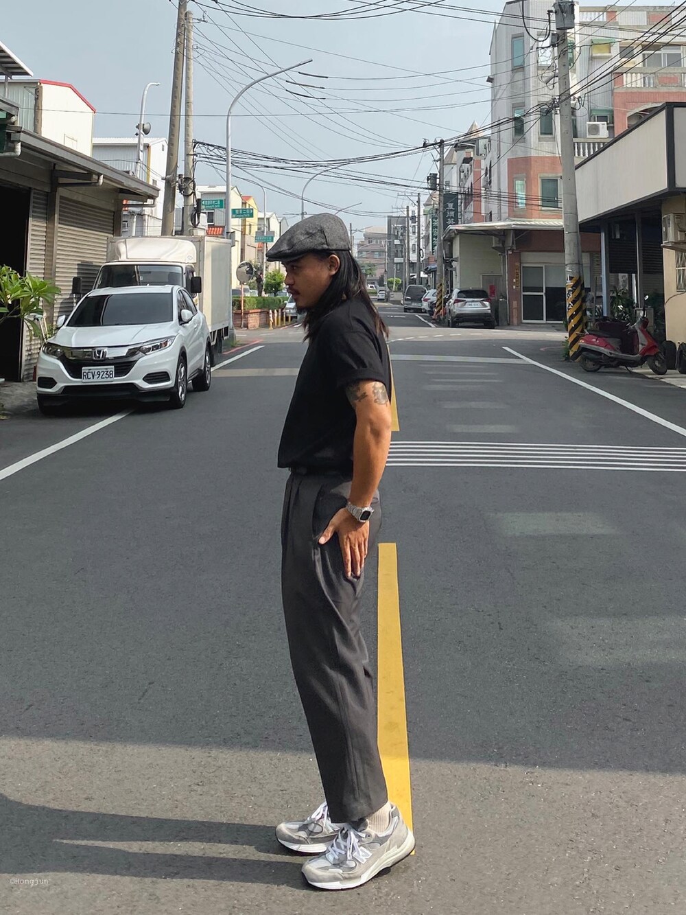 グレー系のスラックス、シルバー系のスニーカー、ブラック系のTシャツ/カットソーを着用したメンズの秋コーディネートの3枚目の写真