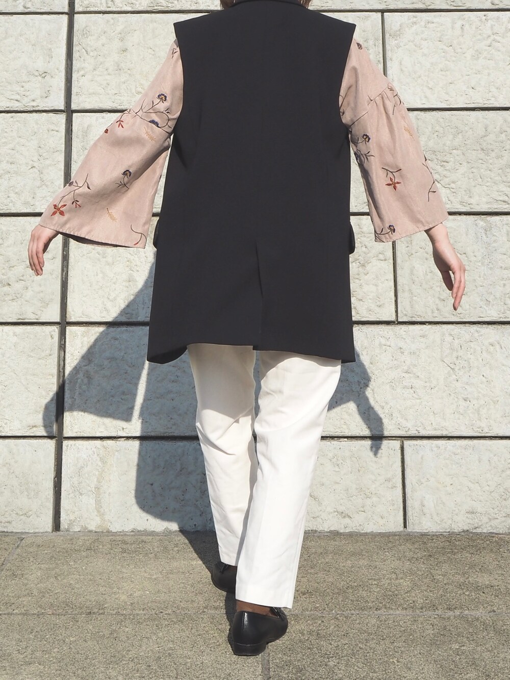 ブラック系のジャケット/アウター、ホワイト系のパンツ、ブラック系のローファーを着用したレディースの春コーディネートの2枚目の写真