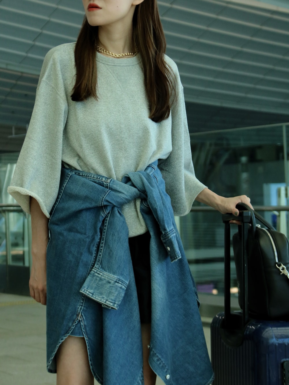 シルバー系のスウェット、ブルー系のシャツ/ブラウス、ブラック系のボストンバッグを着用したレディースの夏コーディネートの2枚目の写真