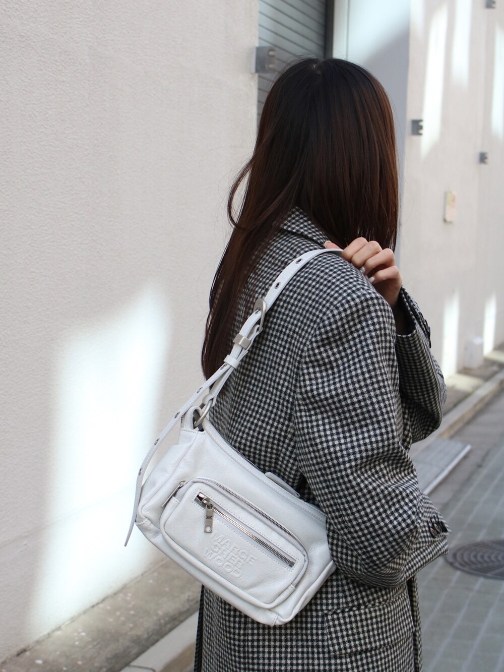 ブルー系のデニムパンツ、ブルー系のデニムパンツ、ホワイト系のショルダーバッグを着用したレディースの春コーディネートの3枚目の写真