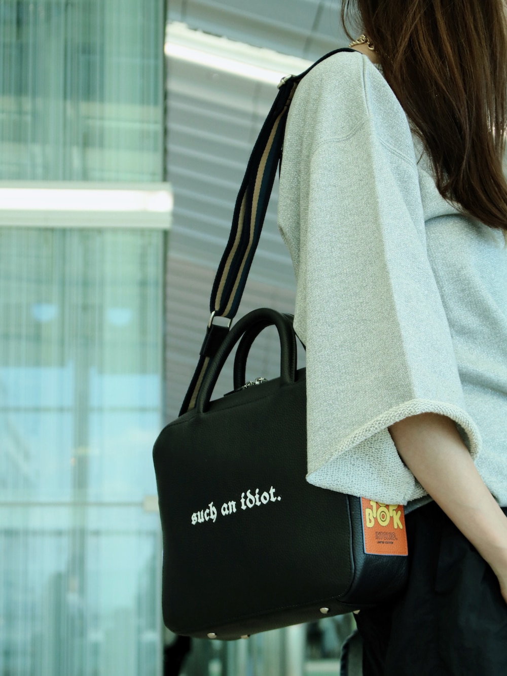 シルバー系のスウェット、ブルー系のシャツ/ブラウス、ブラック系のボストンバッグを着用したレディースの夏コーディネートの4枚目の写真