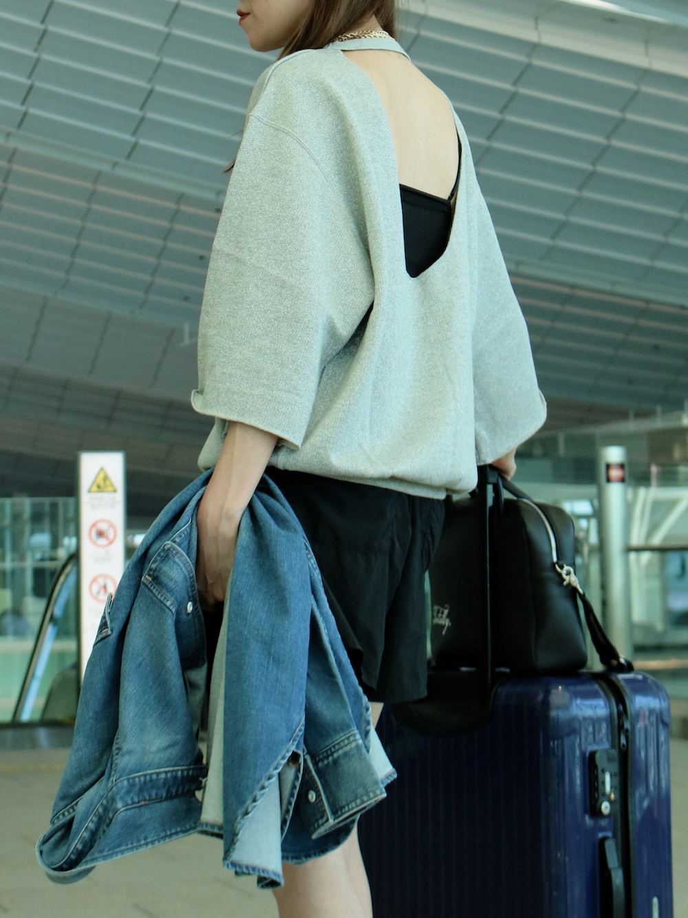 シルバー系のスウェット、ブルー系のシャツ/ブラウス、ブラック系のボストンバッグを着用したレディースの夏コーディネートの3枚目の写真