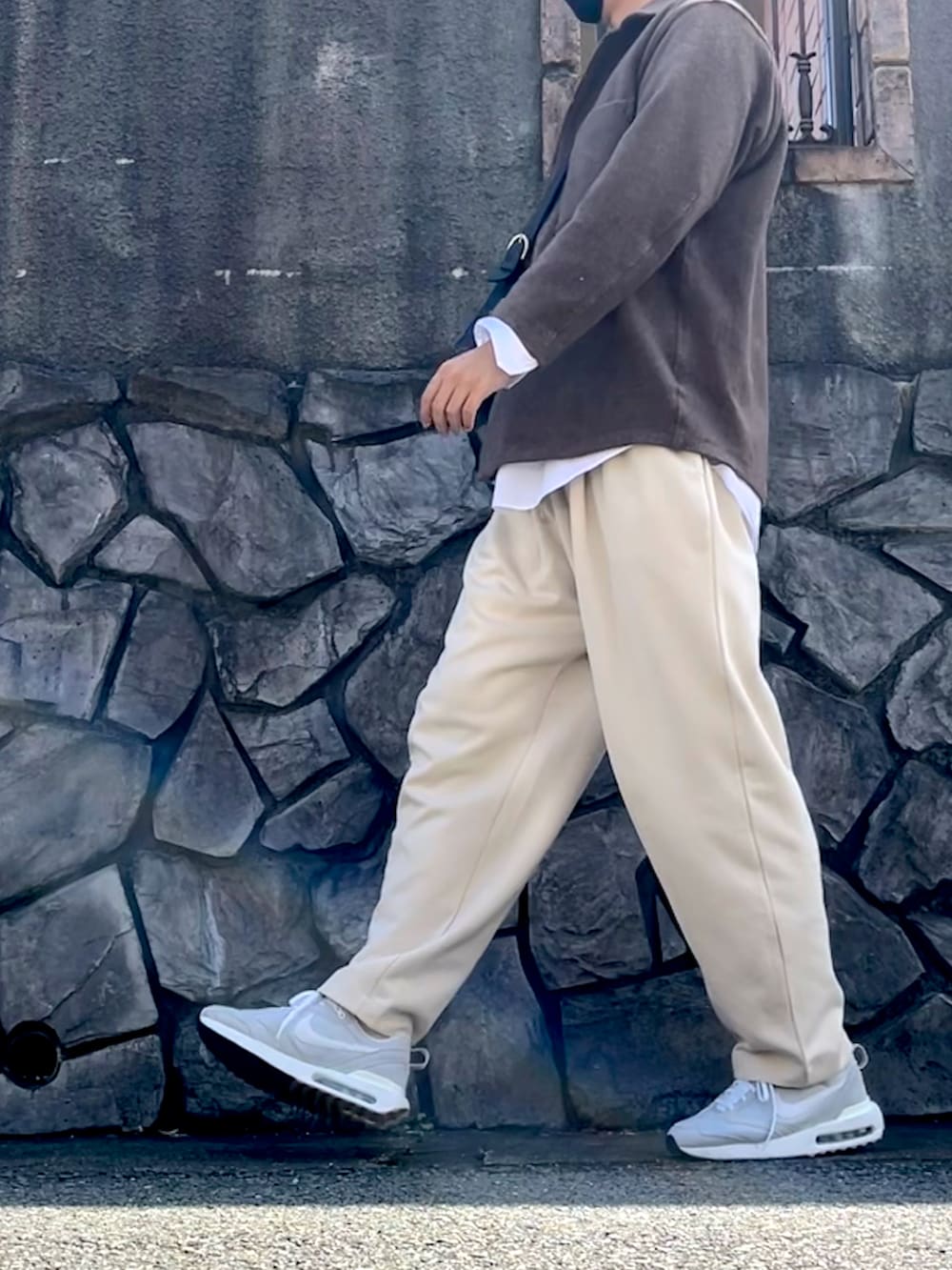 ホワイト系のスウェットパンツ、グレー系のスニーカー、グレー系のショルダーバッグを着用したメンズの春コーディネートの2枚目の写真