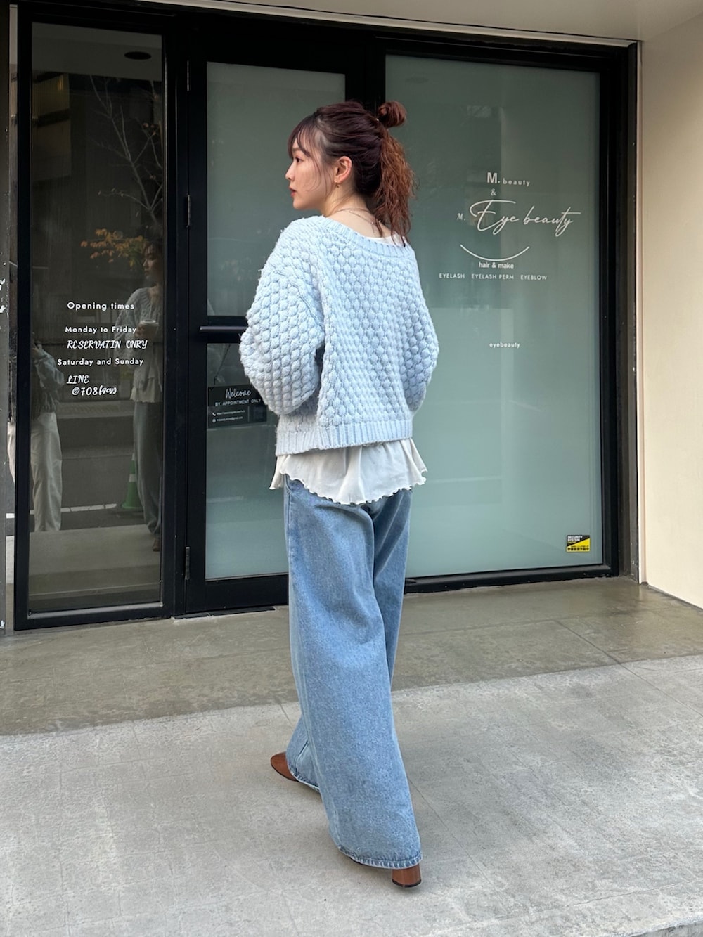ブルー系のカーディガン/ボレロ、ホワイト系のTシャツ/カットソー、ブラック系のボストンバッグを着用したレディースの冬コーディネートの2枚目の写真