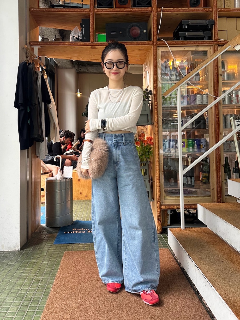 ベージュ系のトートバッグ、ブルー系のデニムパンツ、ホワイト系のTシャツ/カットソーを着用したレディースの秋コーディネートの2枚目の写真