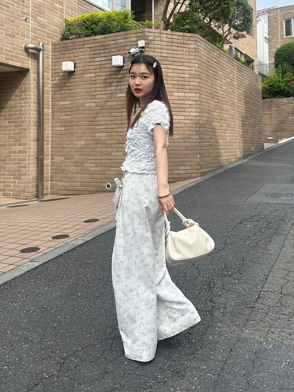 ホワイト系のTシャツ/カットソー、ホワイト系のハンドバッグ、ホワイト系のその他パンツを着用したレディースの夏コーディネートの3枚目の写真