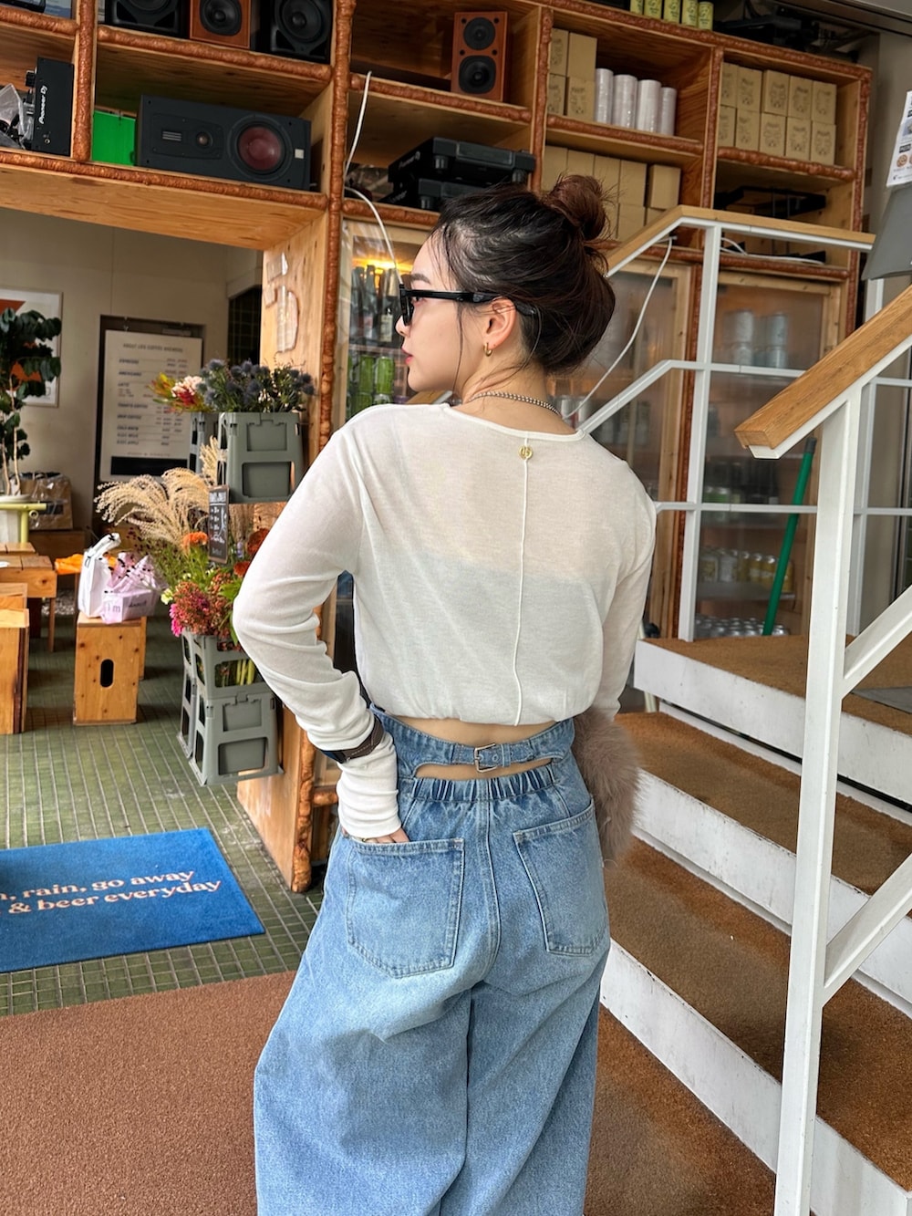 ベージュ系のトートバッグ、ブルー系のデニムパンツ、ホワイト系のTシャツ/カットソーを着用したレディースの秋コーディネートの3枚目の写真