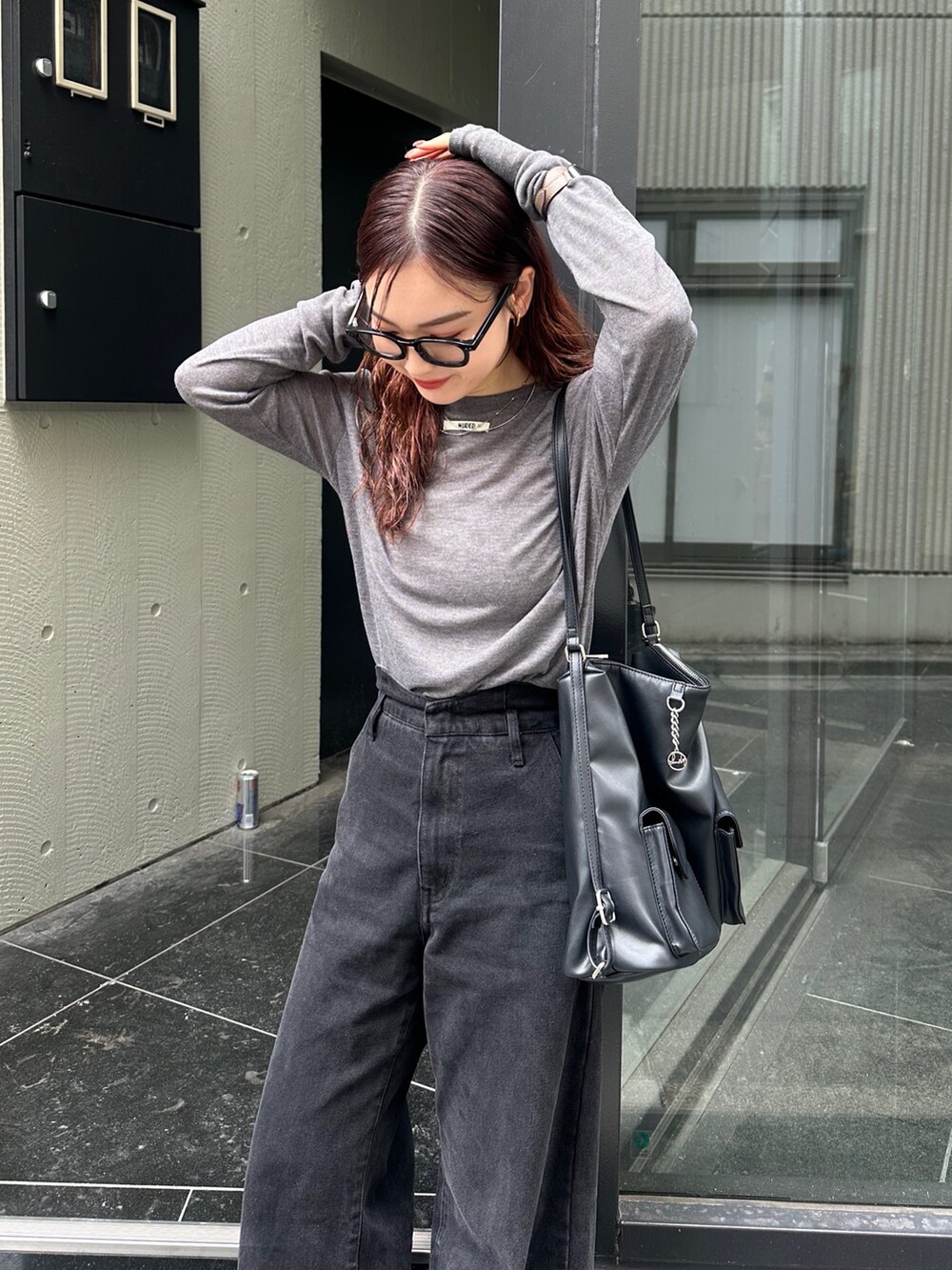 ブラック系のトートバッグ、ブラック系のデニムパンツ、グレー系のTシャツ/カットソーを着用したレディースの秋コーディネートの2枚目の写真