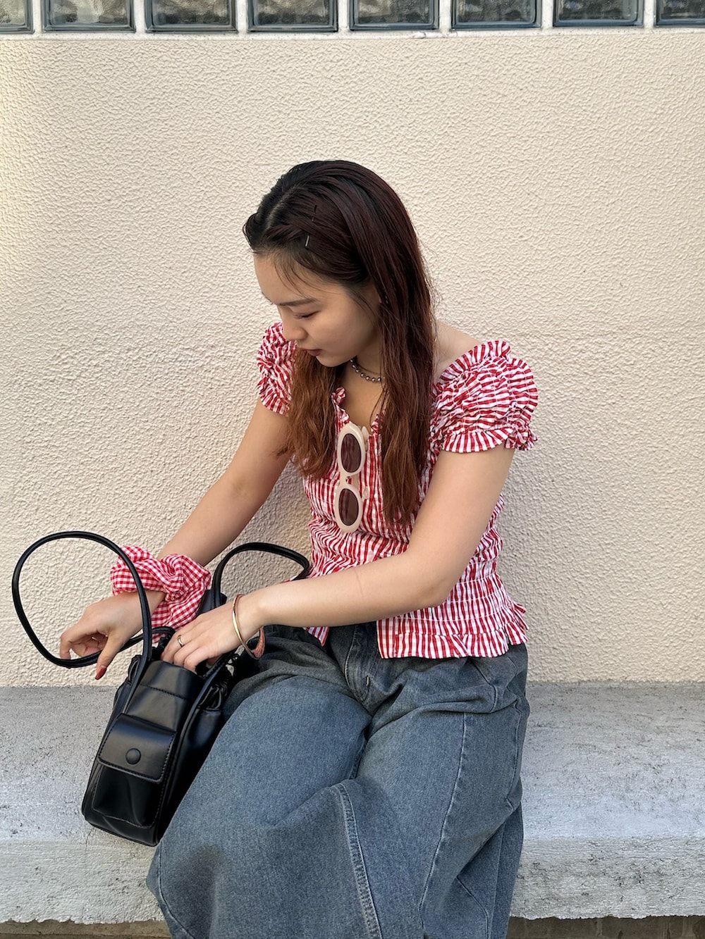 レッド系のシャツ/ブラウス、ブルー系のデニムパンツ、レッド系のシュシュを着用したレディースの春コーディネートの2枚目の写真