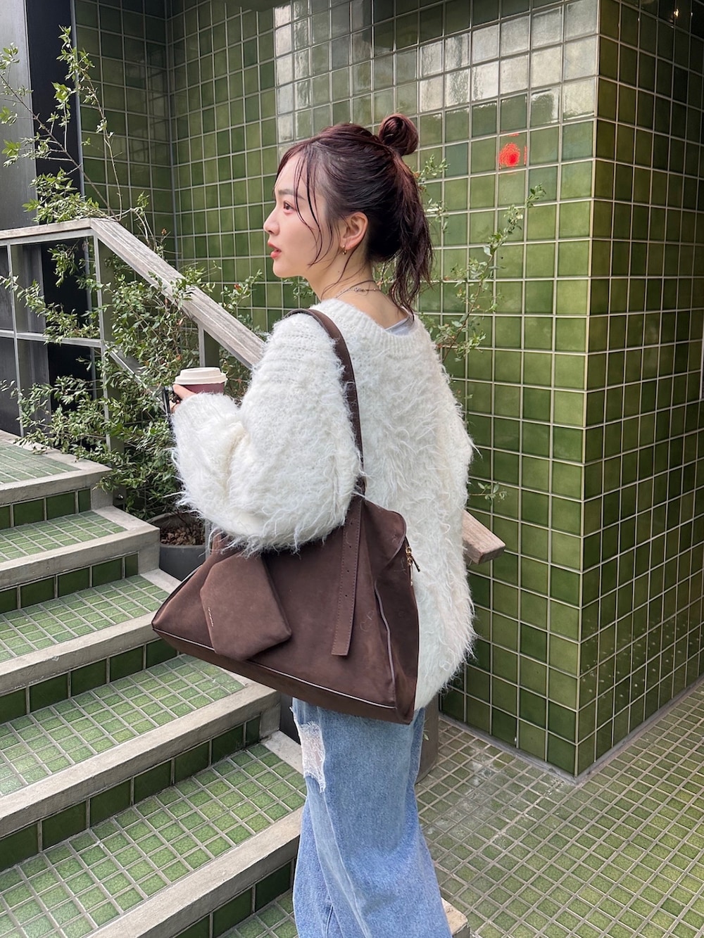 ブルー系のTシャツ/カットソー、ホワイト系のニット/セーター、ブラウン系のボストンバッグを着用したレディースの秋コーディネートの2枚目の写真