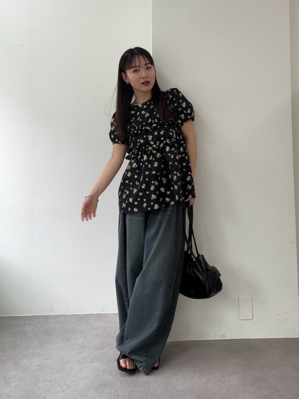 ブラック系のシャツ/ブラウス、ブルー系のデニムパンツ、ブラック系のサンダルを着用したレディースの春コーディネートの2枚目の写真