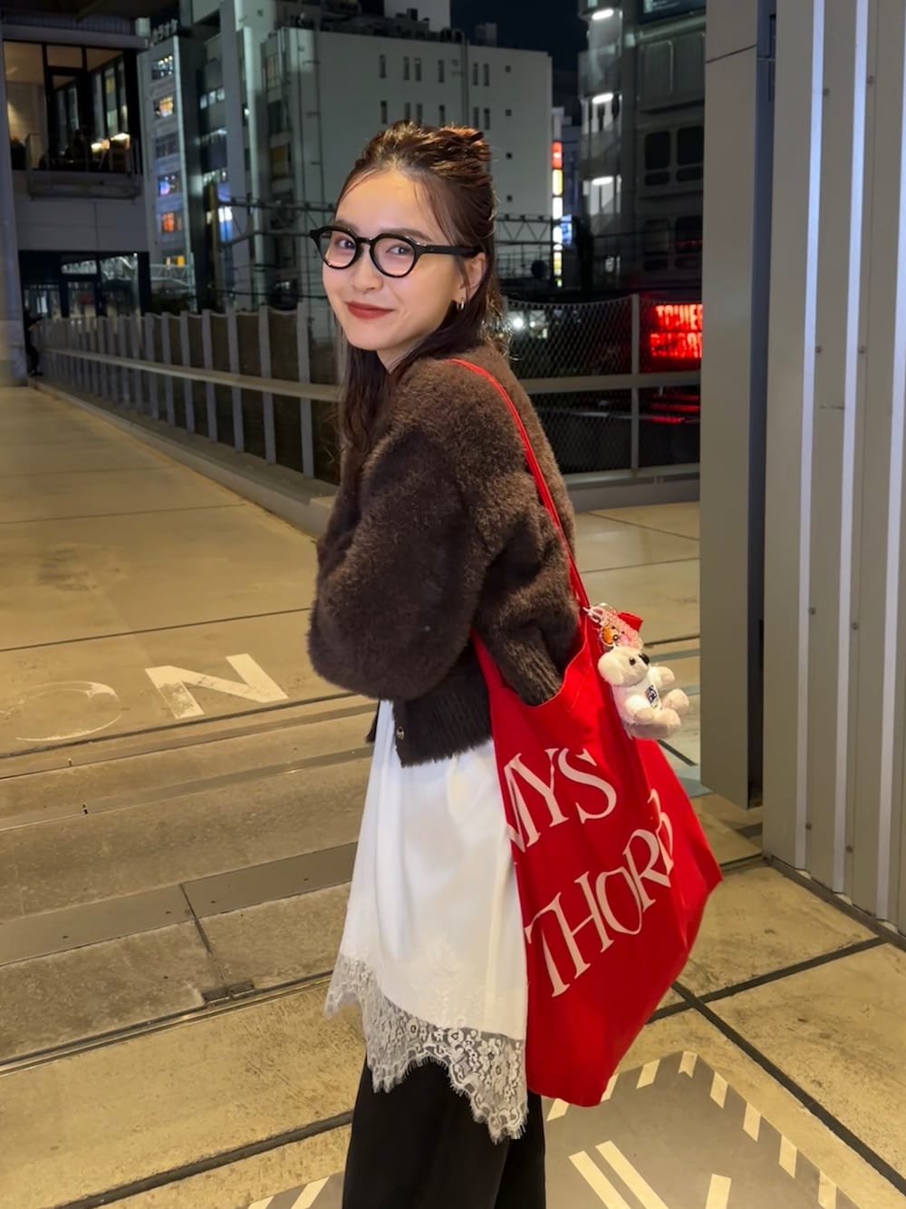 ブラック系のデニムパンツ、ブラウン系のカーディガン/ボレロ、ブラック系のブーツを着用したレディースの秋コーディネートの2枚目の写真