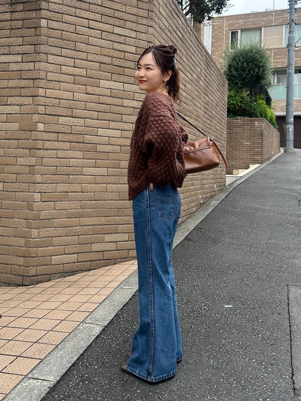 ブラウン系のカーディガン/ボレロ、ホワイト系のTシャツ/カットソー、イエロー系のショルダーバッグを着用したレディースの秋コーディネートの3枚目の写真