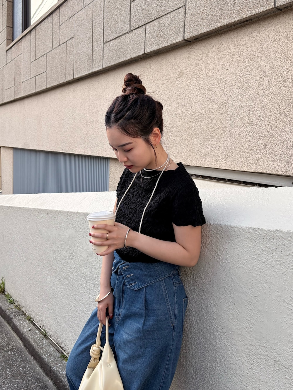 ブルー系のデニムパンツ、ブラック系のシャツ/ブラウス、ホワイト系のリングを着用したレディースの春コーディネートの2枚目の写真