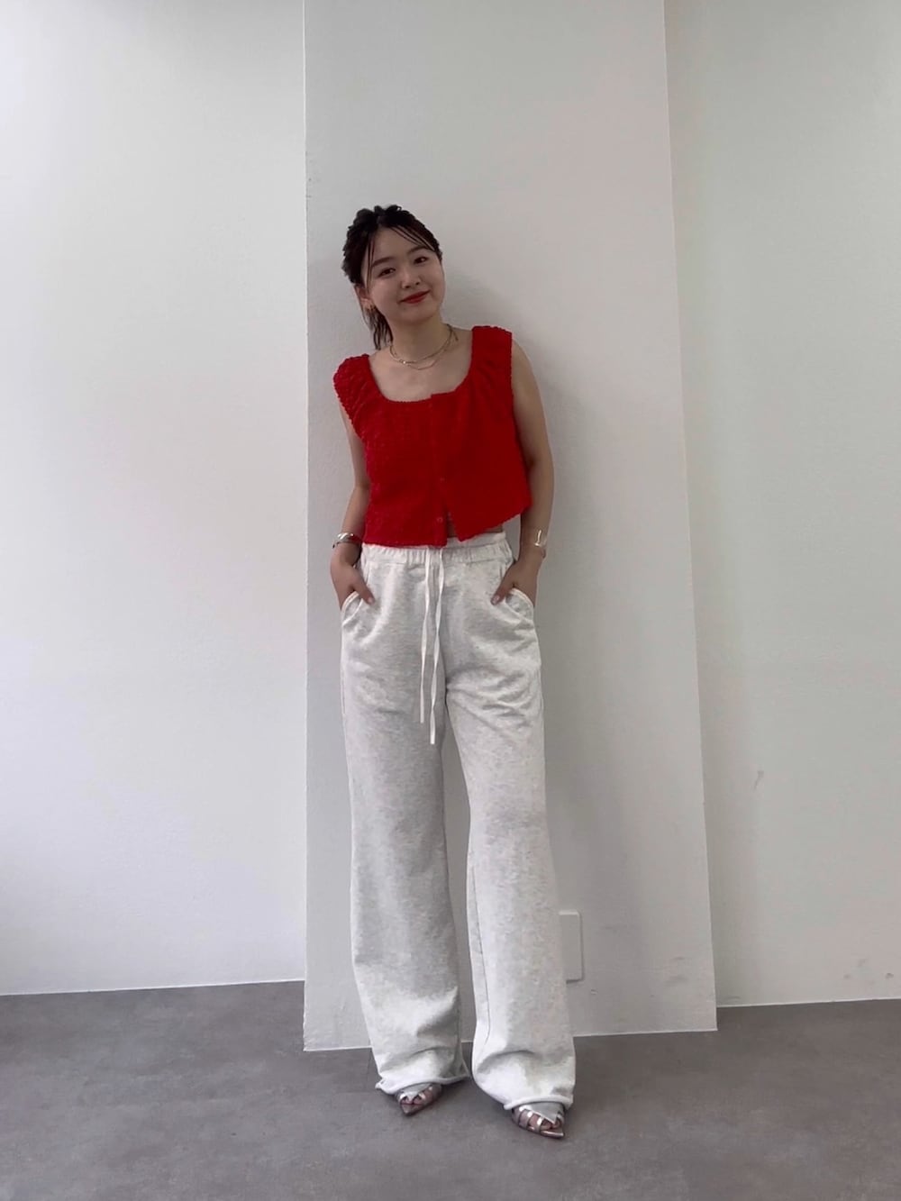 グレー系のスウェットパンツ、シルバー系のサンダル、レッド系のタンクトップを着用したレディースの春コーディネートの2枚目の写真
