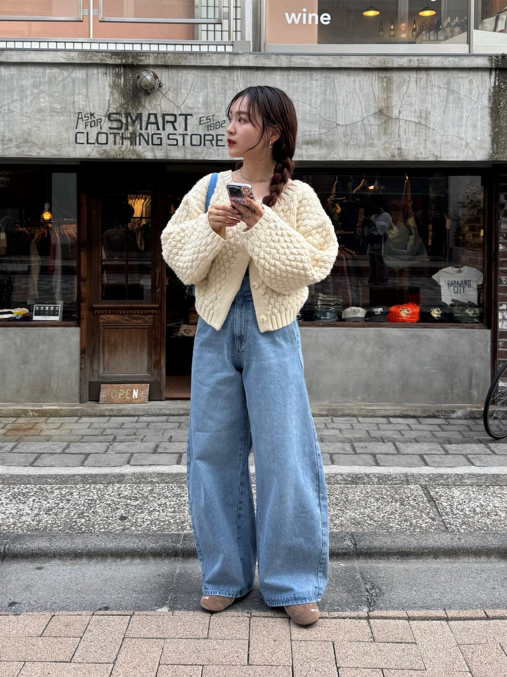 ブルー系のデニムパンツ、ホワイト系のカーディガン/ボレロを着用したレディースの秋コーディネートの2枚目の写真