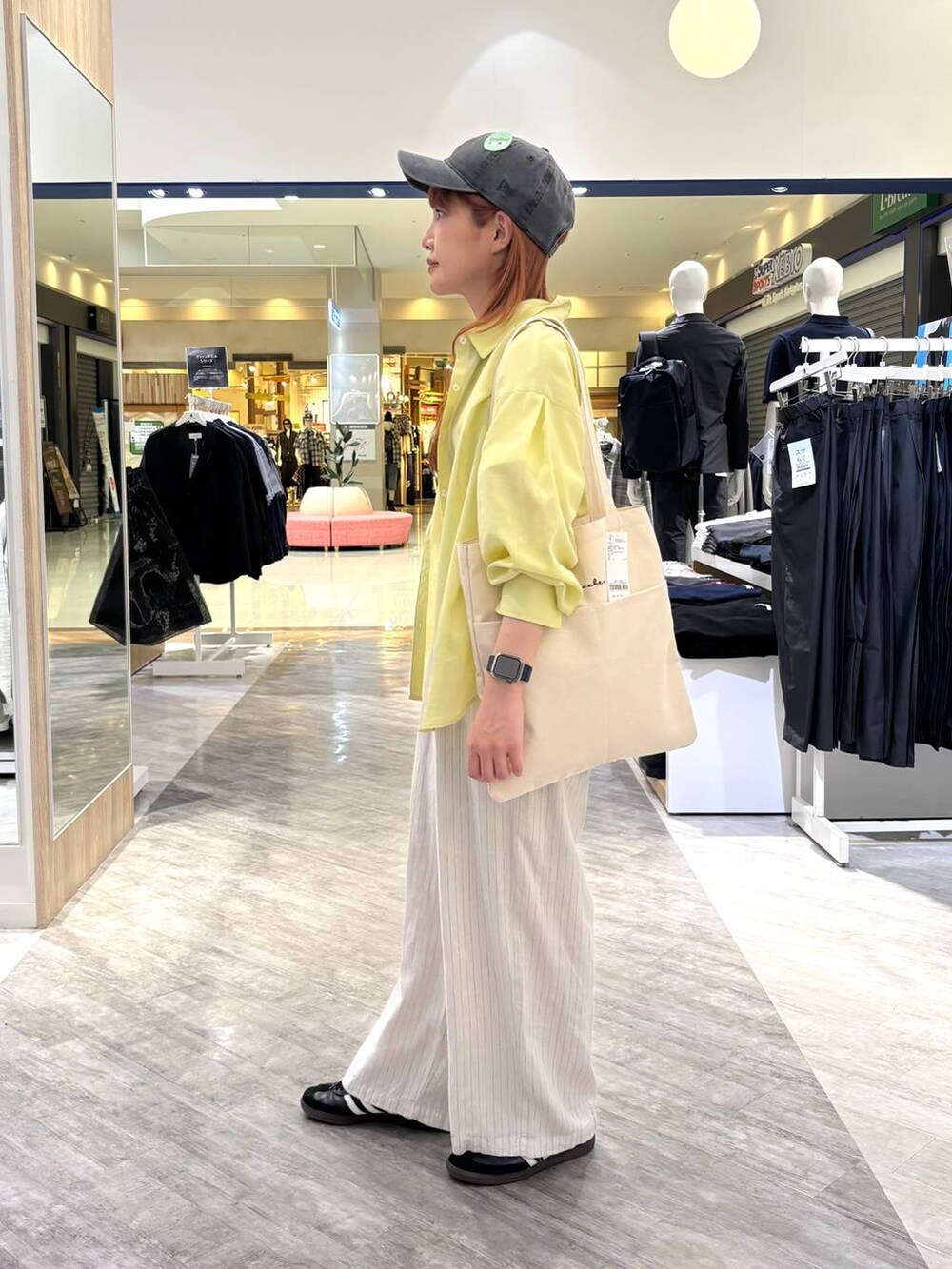 ホワイト系のトートバッグ、ベージュ系のその他パンツ、ホワイト系のTシャツ/カットソーを着用したレディースの春コーディネートの2枚目の写真