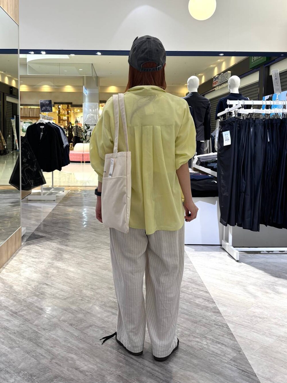 ホワイト系のトートバッグ、ベージュ系のその他パンツ、ホワイト系のTシャツ/カットソーを着用したレディースの春コーディネートの3枚目の写真