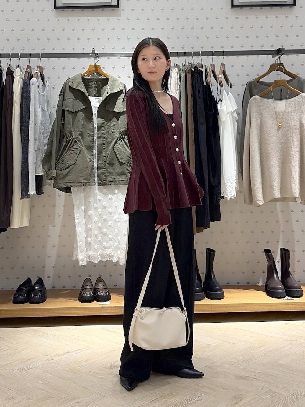 ホワイト系のショルダーバッグ、レッド系のカーディガン/ボレロ、ブラック系のパンプスを着用したレディースの秋コーディネートの4枚目の写真