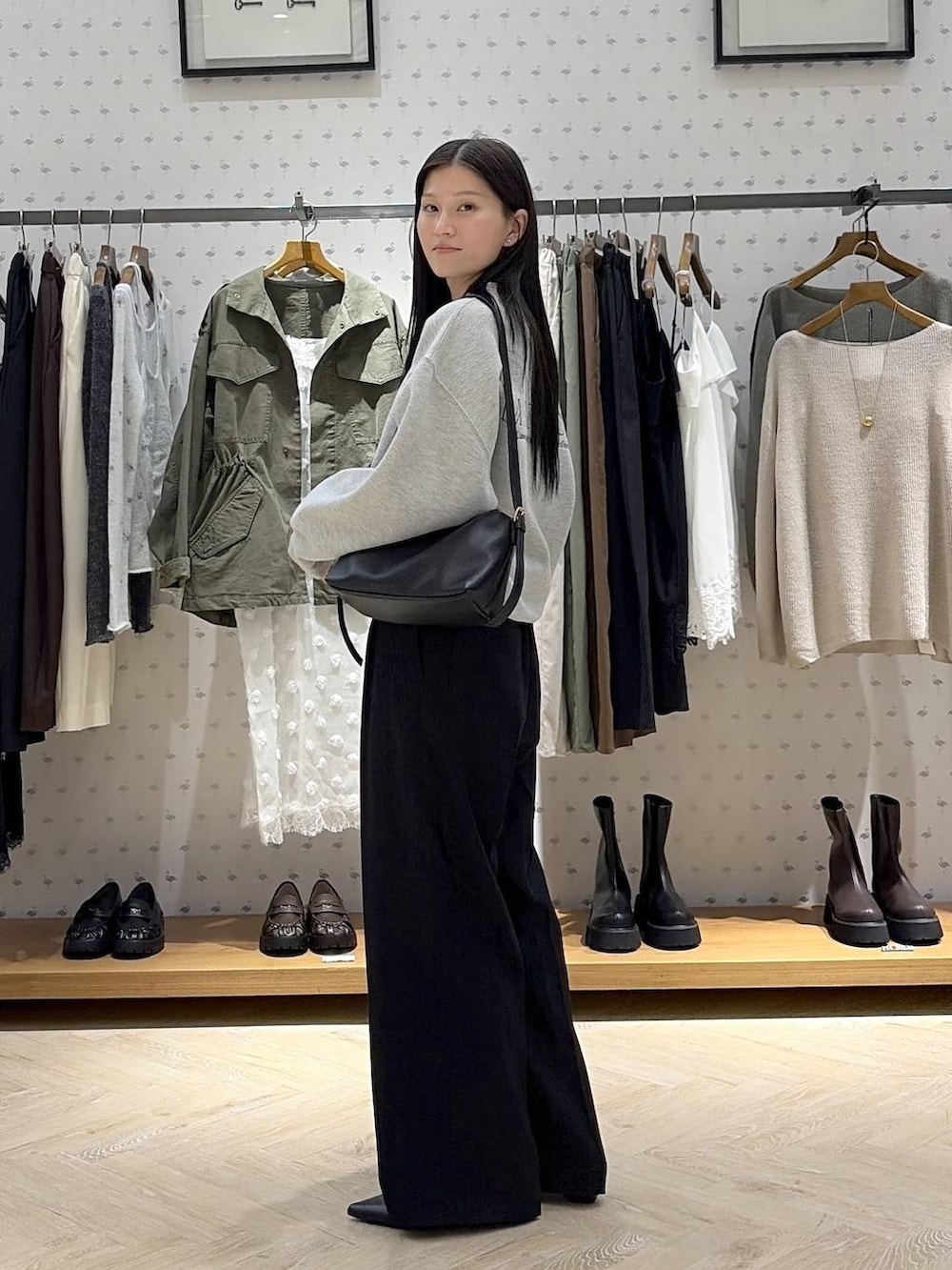 ブラック系のショルダーバッグ、グレー系のスウェット、ブラック系のパンプスを着用したレディースの秋コーディネートの2枚目の写真