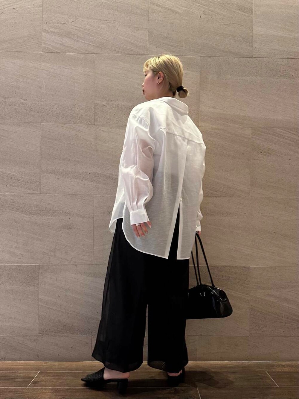 ブラック系のその他パンツ、ホワイト系のシャツ/ブラウス、ブラック系のボストンバッグを着用したレディースの春コーディネートの3枚目の写真